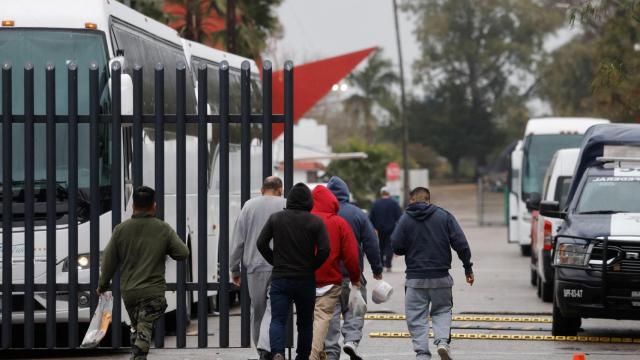 Migrantes deportados por EEEUU se dirigen a un autobús del Instituto Nacional de Migración (INM) de México, en la localidad de Matamoros.