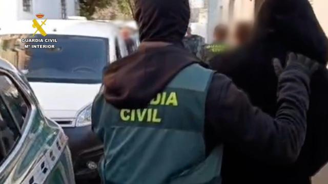 Un agente de la Guardia Civil acompaña a uno de los detenidos en esta operación contra el narcotráfico.