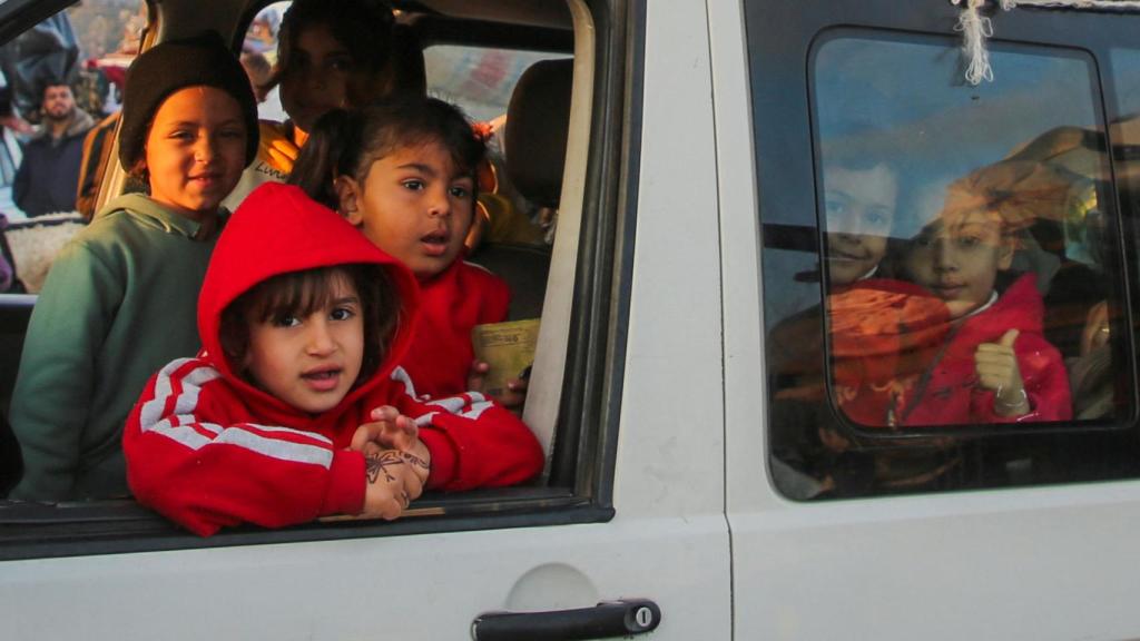 Varios niños en un coche emprendiendo el regreso a sus casas en el norte.