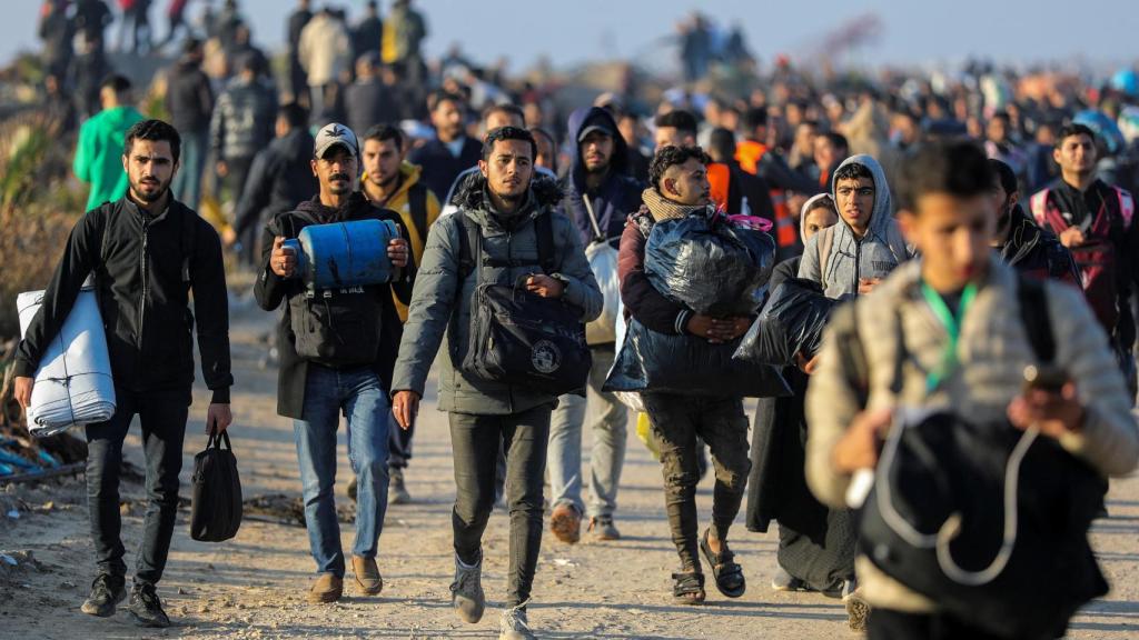 Un grupo de palestinos dirigiéndose a pie hacia el norte.