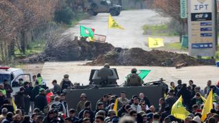 Un grupo de personas sostiene banderas de Hezbolá cerca de Kfar Kila, al sur del Líbano.