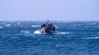 Un cayuco que había zarpado de Senegal luce una bandera española al acercare a la isla canaria de El Hierro.