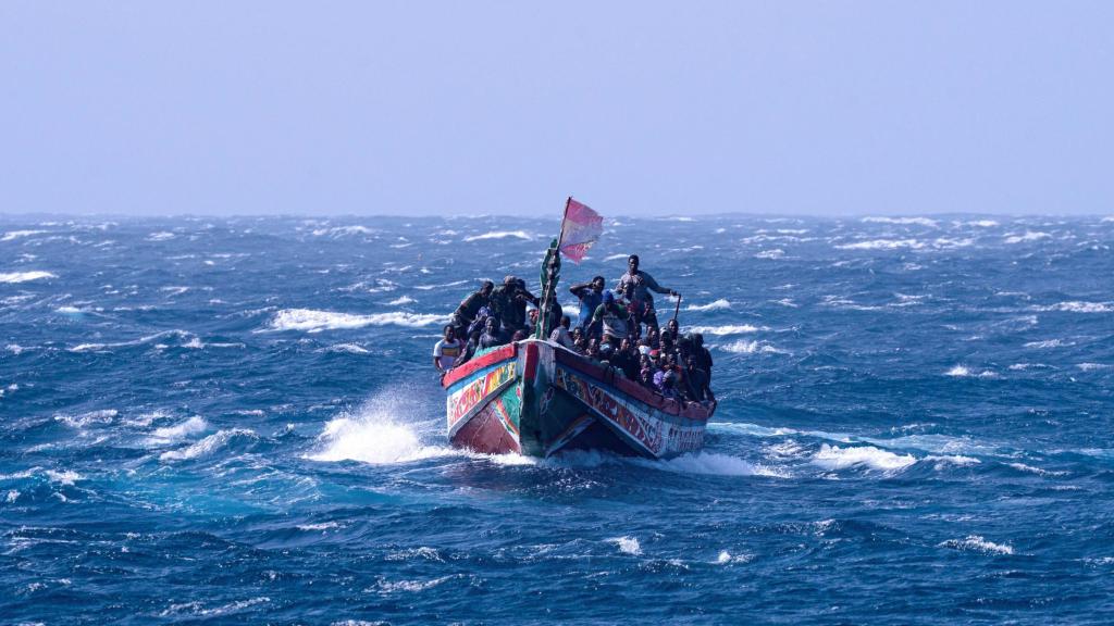 Un cayuco procedente de Senegal luce una bandera española al acercare a la isla canaria de El Hierro.