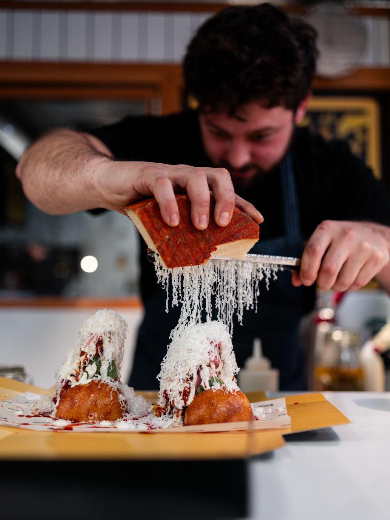 Aldo Sebastianelli rallando el parmesano en la costilla glaseada.