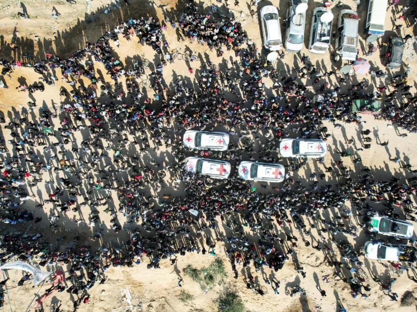 Una vista de un dron muestra a una multitud rodeando a los vehículos de la Cruz Roja durante la entrega de dos rehenes en Jan Yunis.
