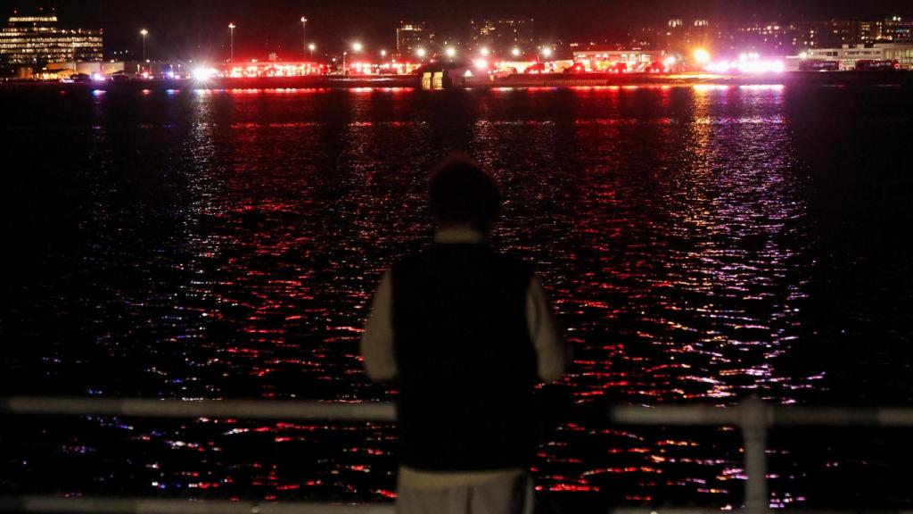 Una persona observa los trabajos de rescate en el río Potomac.
