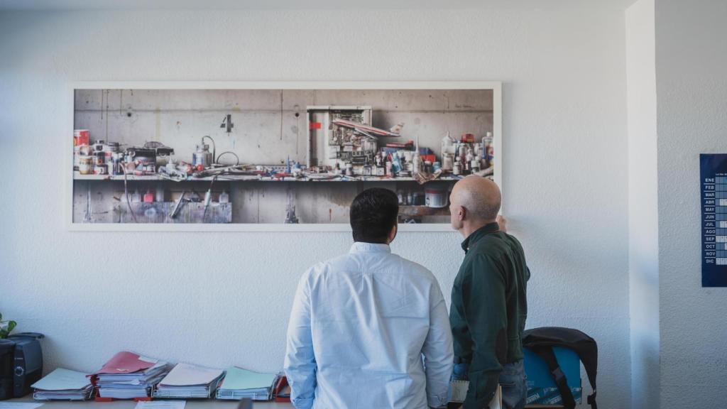 El Inspector Espadas (d) muestra una prueba del artista César Galicia, colgado en una pared de las dependencias policiales, a EL ESPAÑOL.