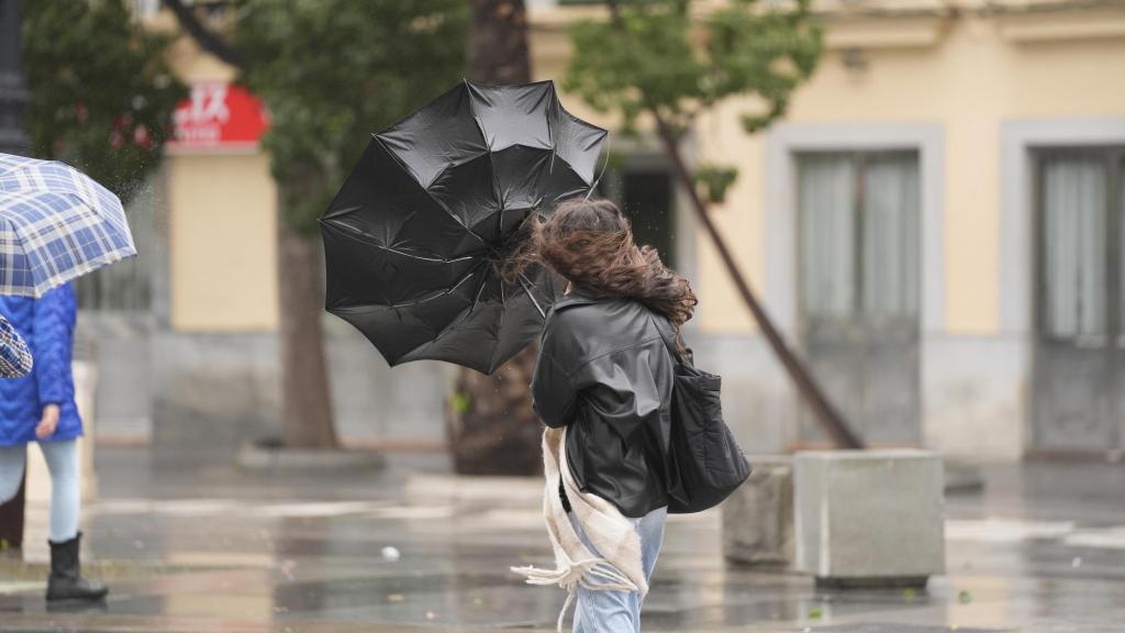 Una mujer, con problemas para llevar su paraguas, durante el paso de la borrasca Herminia por Sevilla.