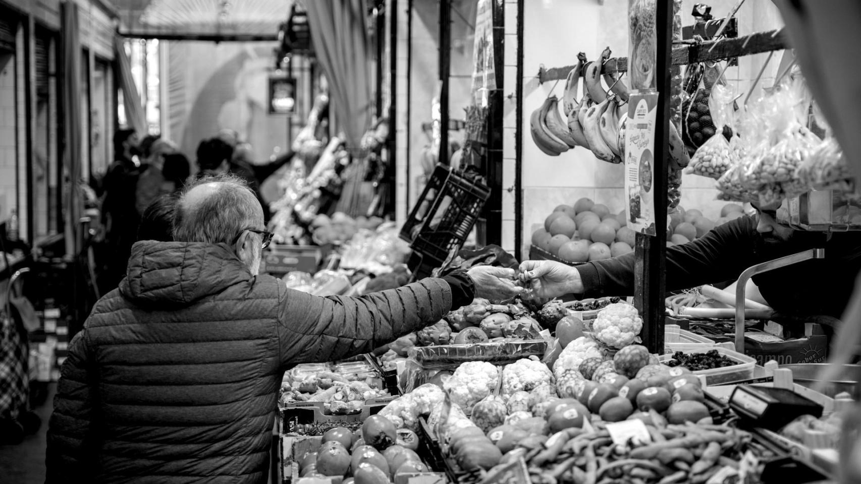 Un hombre en un puesto del mercado de abastos realiza sus compras