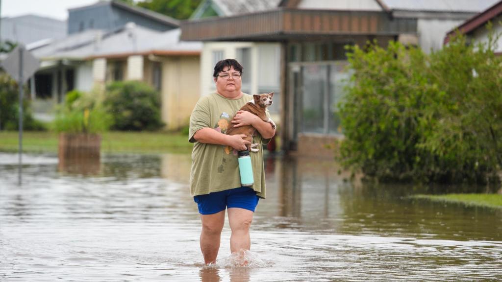 Una vecina de un pueblo al sur de Townsville tratando de salvar a su mascota de las inundaciones.