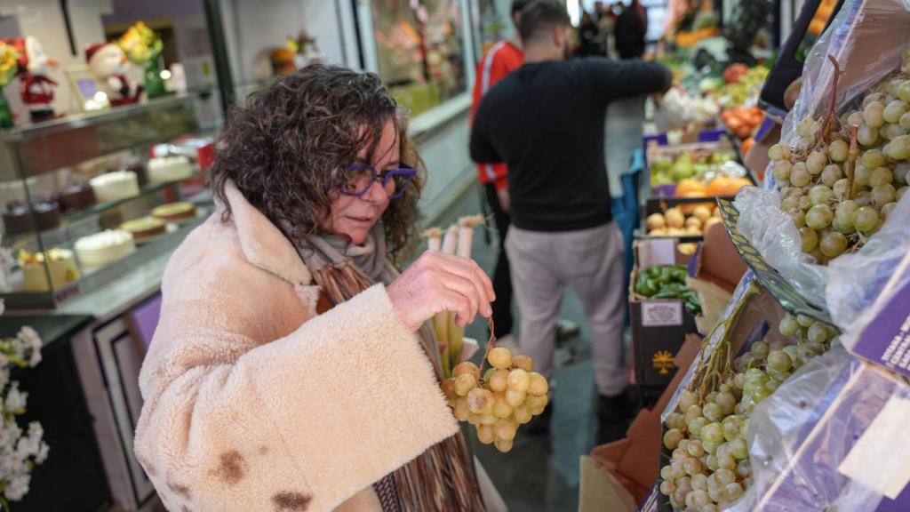 Una mujer compra uvas.