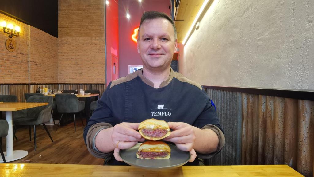 Ángel García, con la hamburguesa con queso de American Humo y Fuego.