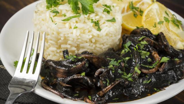 Un plato de chipirones en salsa con arroz