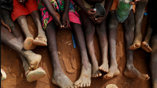 Fotografía de un grupo de niñas sentadas sobre la tierra.
