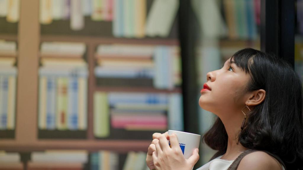 Mujer tomándose un café.