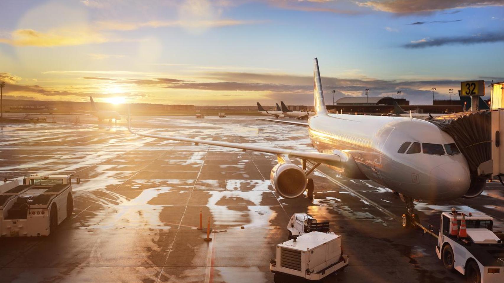 Un avión detenido en la terminal durante el atardecer.