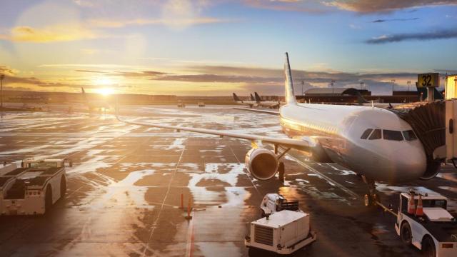 Un avión detenido en la terminal durante el atardecer.