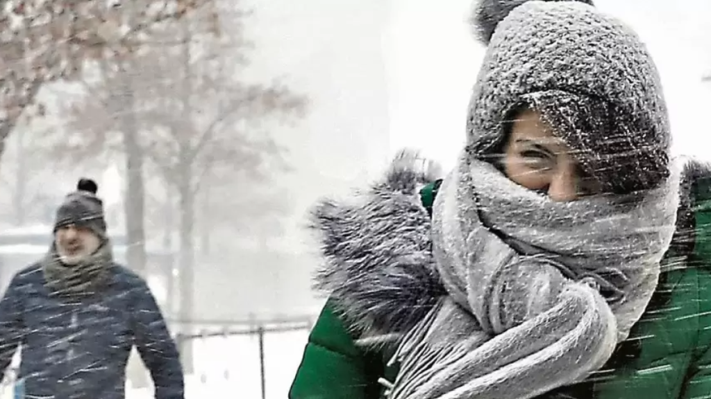 Dos personas intentan resguardarse del frío.