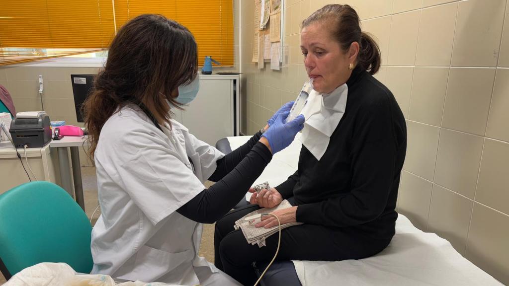 Foto de la médica del servicio de rehabilitación haciendo una exploración en consulta a una paciente con disfagia.