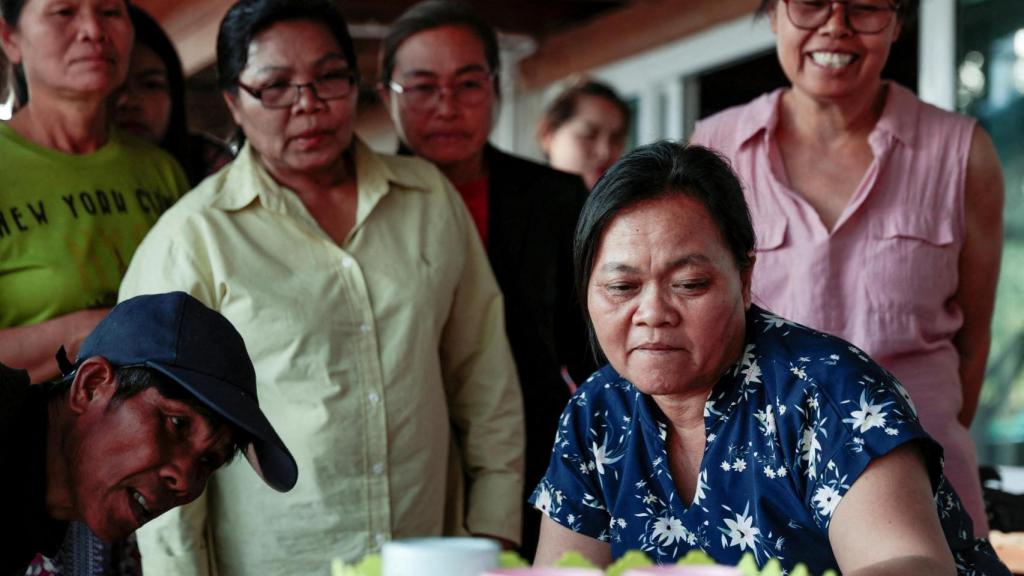 Wiwwaeo Sriaoun, madre del rehén tailandés Watchara Sriaoun, y sus familiares miran las noticias mientras esperan la confirmación de la liberación de su hijo.