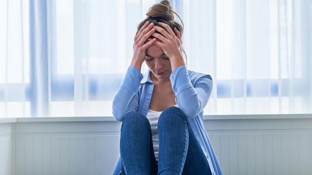 Mujer con ansiedad sobre la cama.
