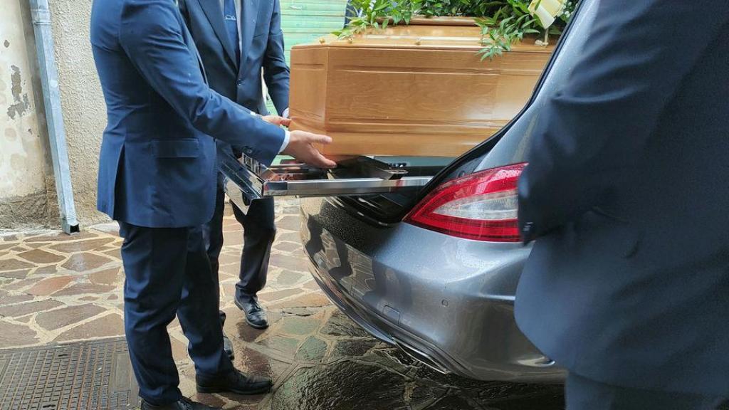 Imagen de archivo de varios empleados de una funeraria extrayendo un ataúd del coche fúnebre.