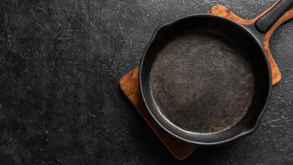 Sartén de hierro sobre tabla de madera.