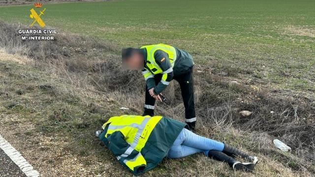 Un guardia civil atiende a la mujer hallada inconsciente en el arcén de una carretera de Palencia