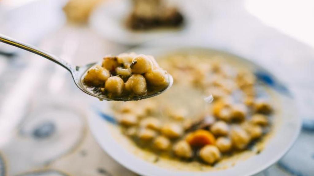 Cuchara con garbanzos recién cogidos del plato.