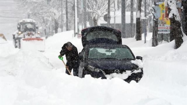 Un hombre intenta retirar nieve alrededor de su coche tras una fuerte nevada en Obihiro, Hokkaido, al norte de Japón.