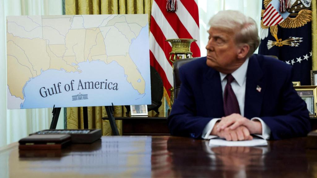 Donald Trump en el Despacho Oval este jueves, junto a un mapa que renombra el Golfo de México como Golfo de América