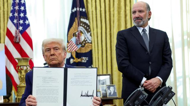 El presidente de Estados Unidos, Donald Trump, muestra la orden ejecutiva sobre los aranceles recíprocos, flanqueado por su nominado a secretario de Comercio de Estados Unidos, Howard Lutnick, en el Despacho Oval de la Casa Blanca.