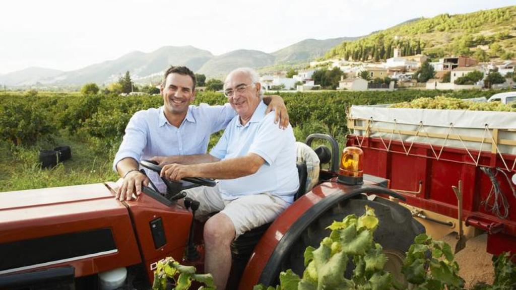 Padre e hijo sentados sobre un tractor.