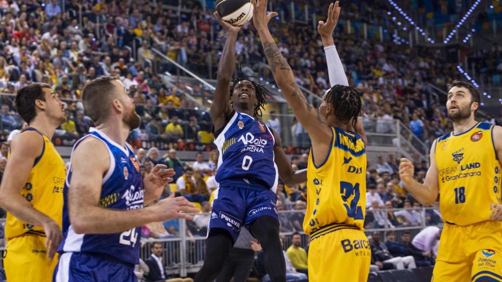 Brancou Badio lanza a canasta ante la presión de Joe Thomasson.