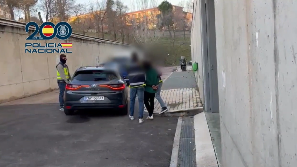 El detenido, esposado y acompañado de los agentes de la CGI de la Policía Nacional.