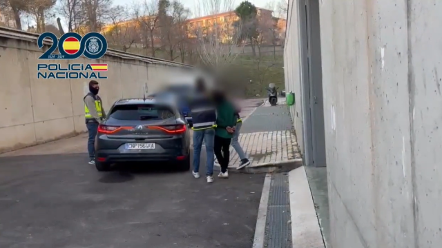 El detenido, esposado y acompañado de los agentes de la CGI de la Policía Nacional.