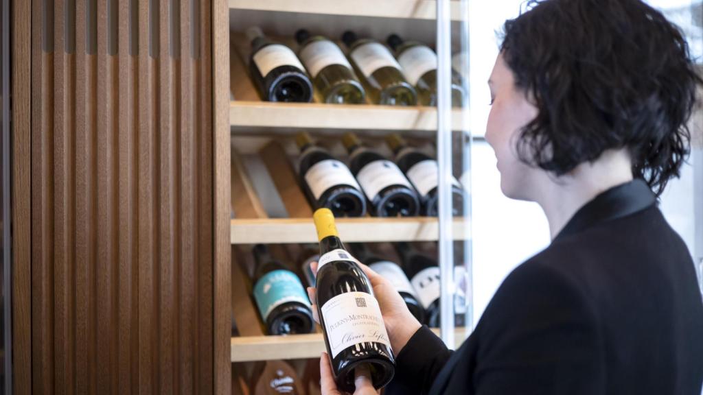 Andrea Martín, con una botella de vino en las manos.