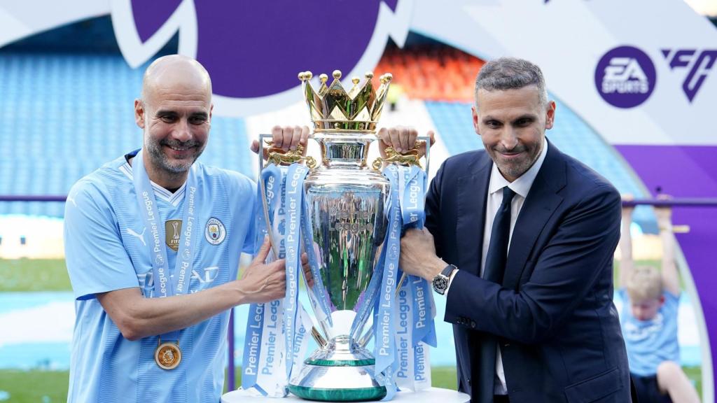 Pep Guardiola sostiene el título de la Premier League junto a Khaldoon Al Mubarak, presidente del Manchester City