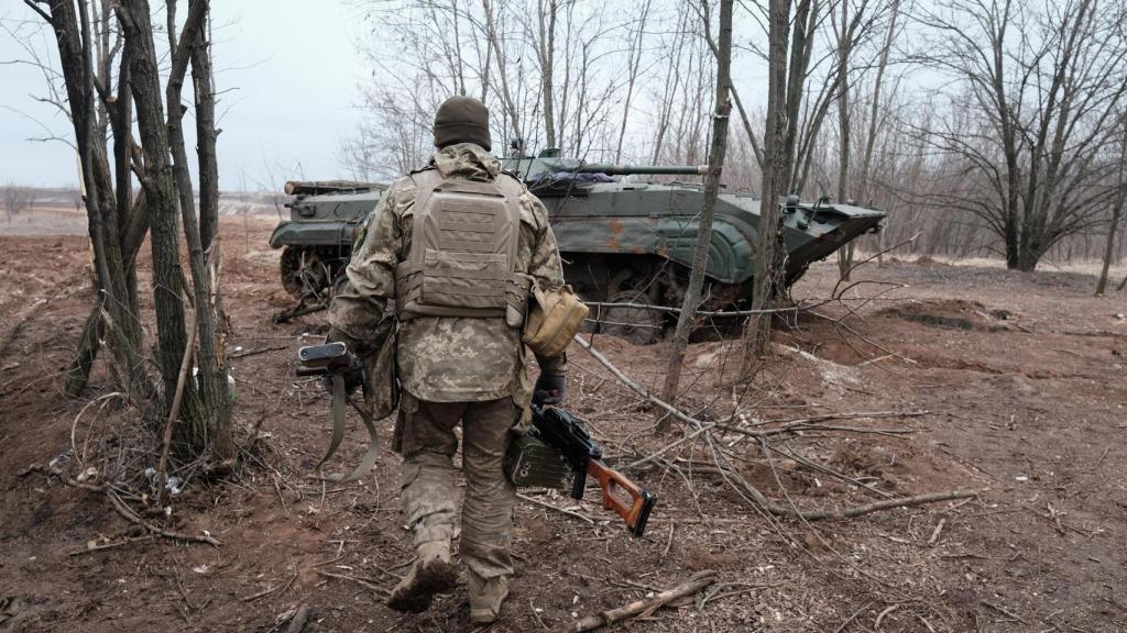 Un soldado del Ejército ucraniano camina hacia un vehículo blindado de transporte de personal BMP-2 en el frente de Bakhmut.