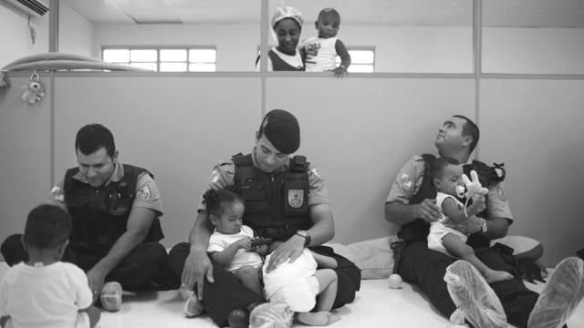 Una de las imágenes que se incluyen en el libro de Sarah Hrdy donde se ve a unos policías jugando y cuidando de bebés en un orfanato.