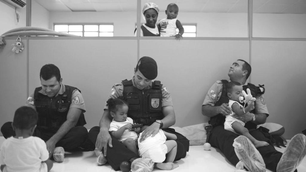 Una de las imágenes que se incluyen en el libro de Sarah Hrdy donde se ve a unos policías jugando y cuidando de bebés en un orfanato.