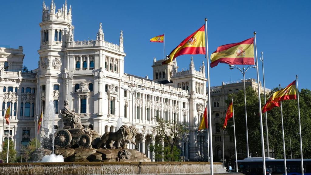 Banderas de España ondeando en la emblemática Fuente de Cibeles, en el corazón de Madrid.