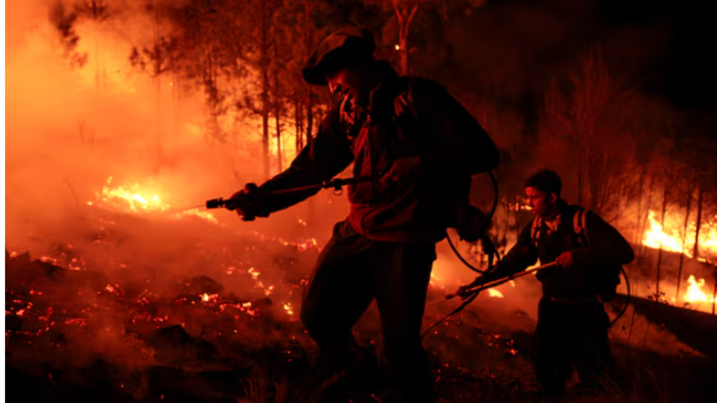 Bomberos que intentan apagar el fuego.