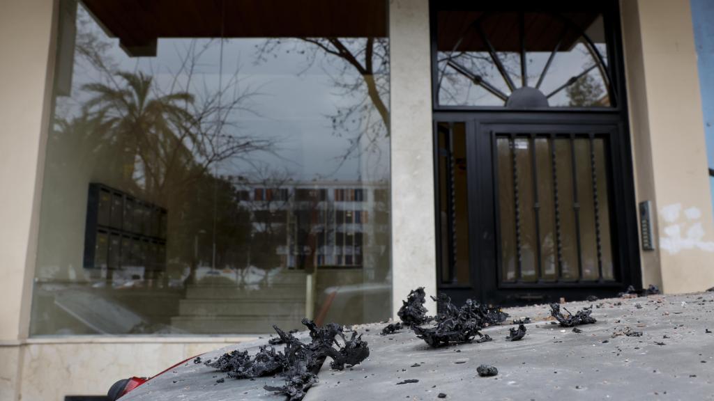 Detalle de restos calcinados ante el portal de la vivienda incendiada. Efe / Ana Escobar