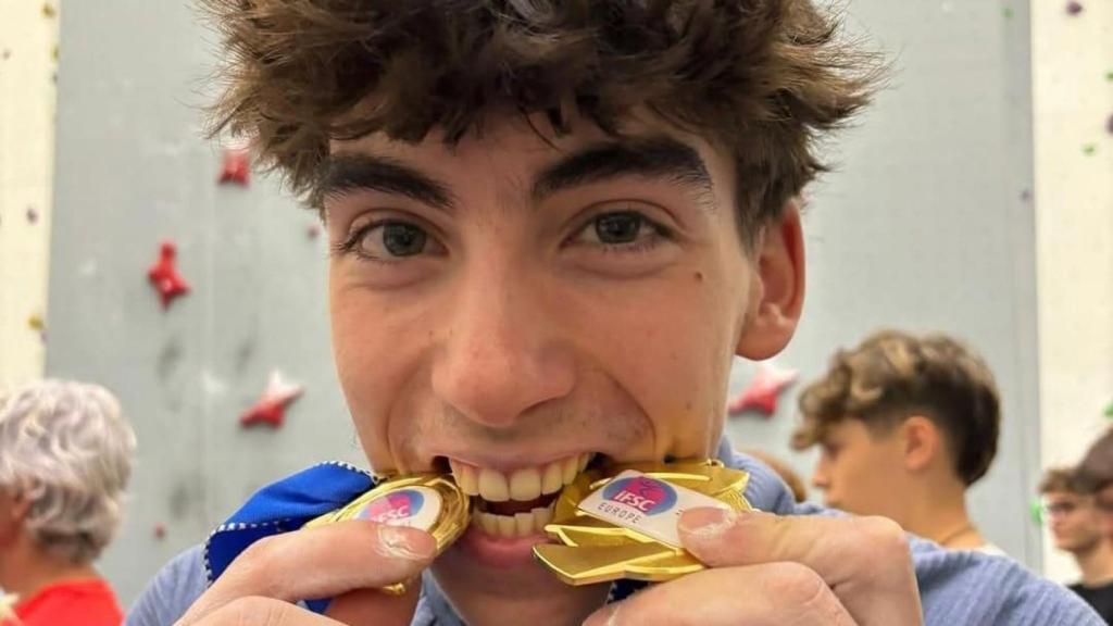 El escalador Guillermo Peinado muerde unas medallas.