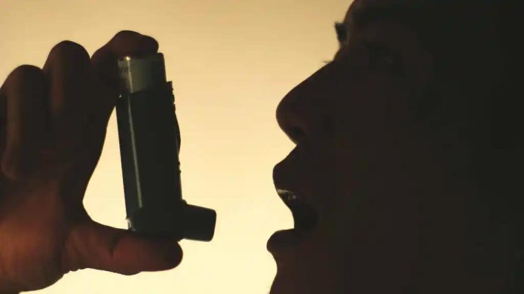 Una persona utiliza un inhalador de gas presurizado.