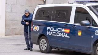 Un hombre se apoya en un furgón de la Policía Nacional estacionado en Toledo.