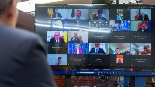 Alberto Núñez Feijóo, de espaldas y en pantalla, durante la cumbre extraordinaria del PPE por la Europa de la Defensa.