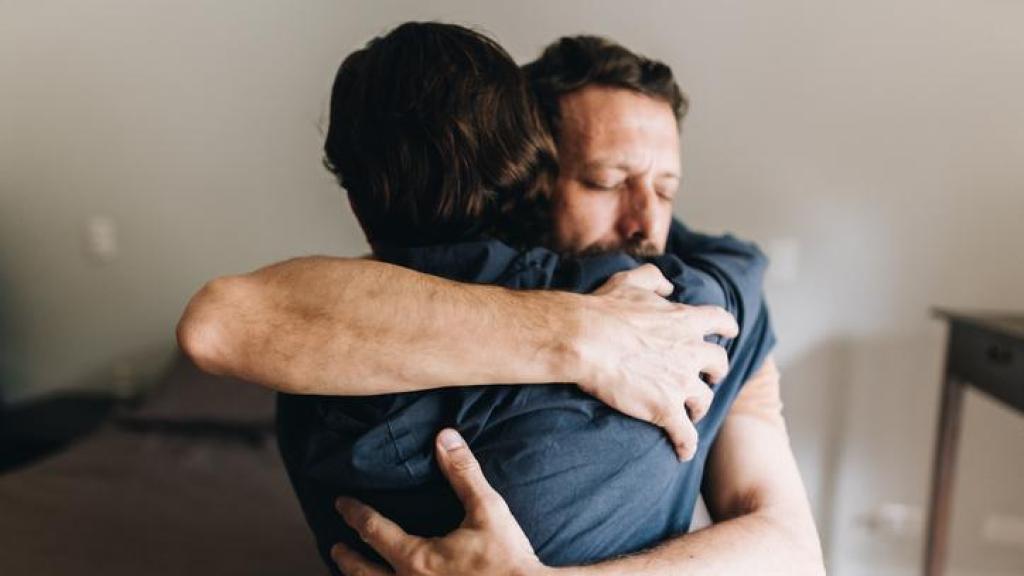 Dos personas abrazándose.