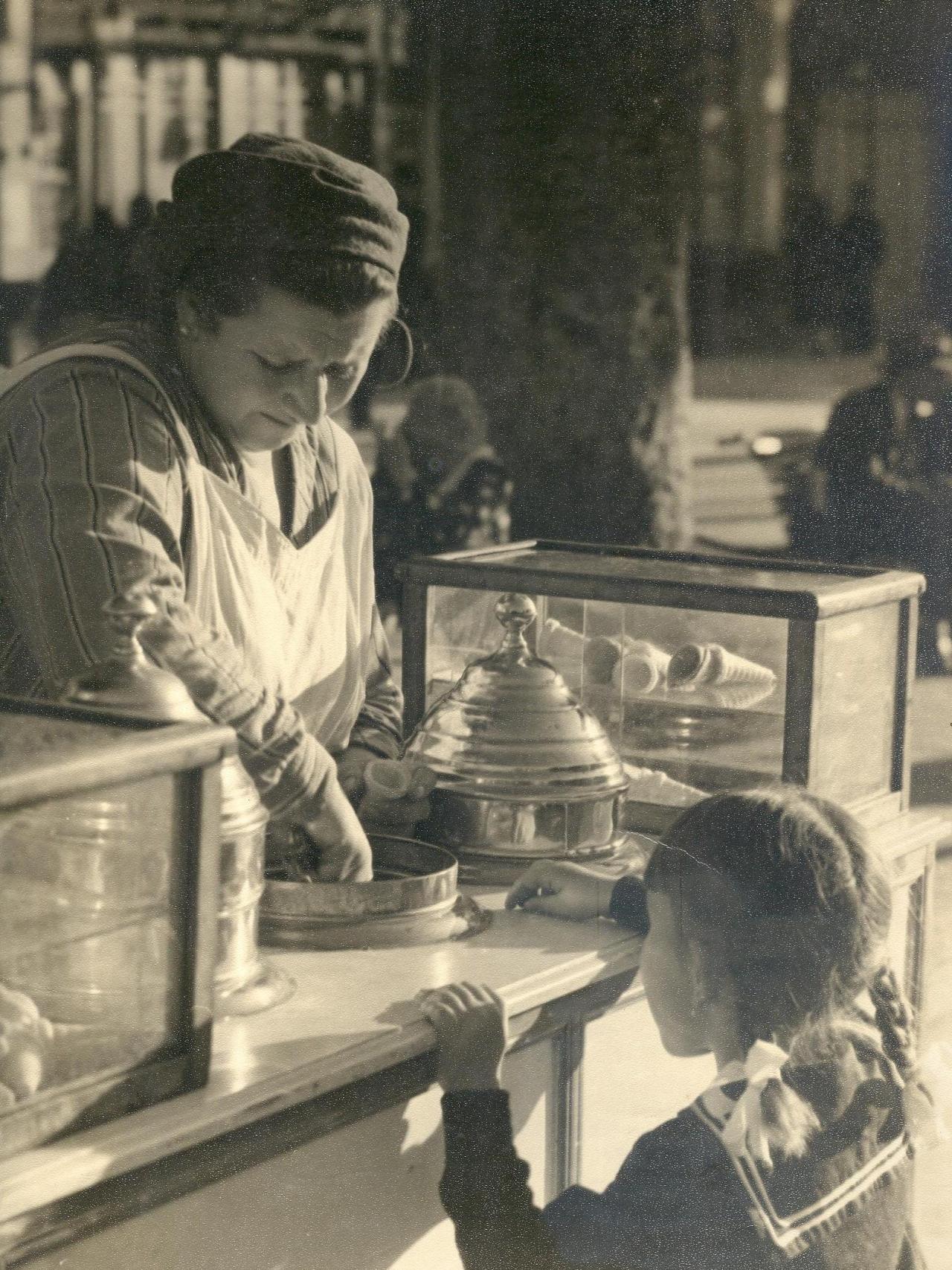 Foto con una mujer preparando un helado para una niña.